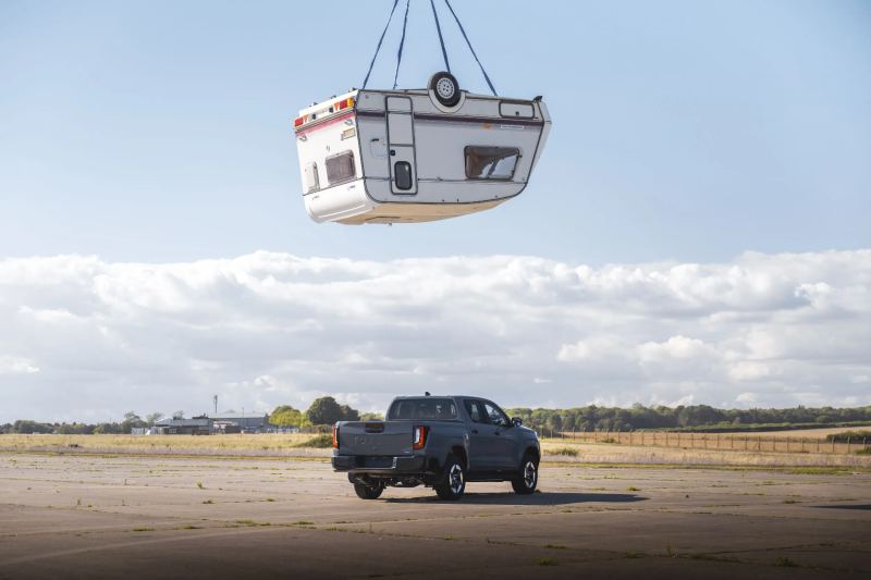 Toyota Drops a Caravan on the Hilux BEV to Recreate Top Gear’s Famous Test